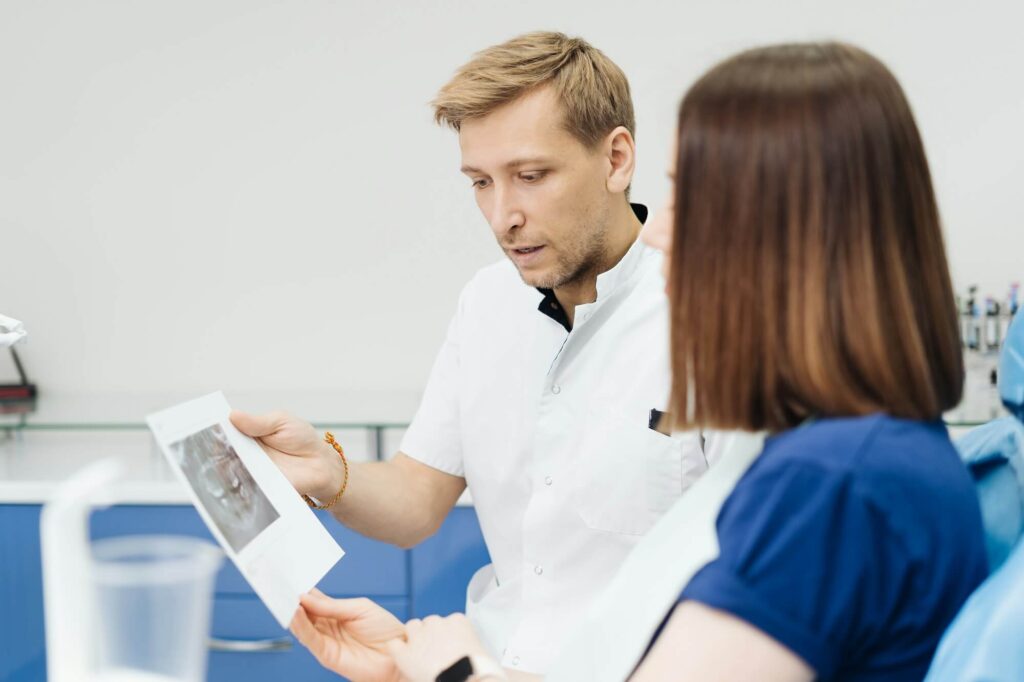 Doctor consulting his patient discussing tooth treatment plan health care.jpg